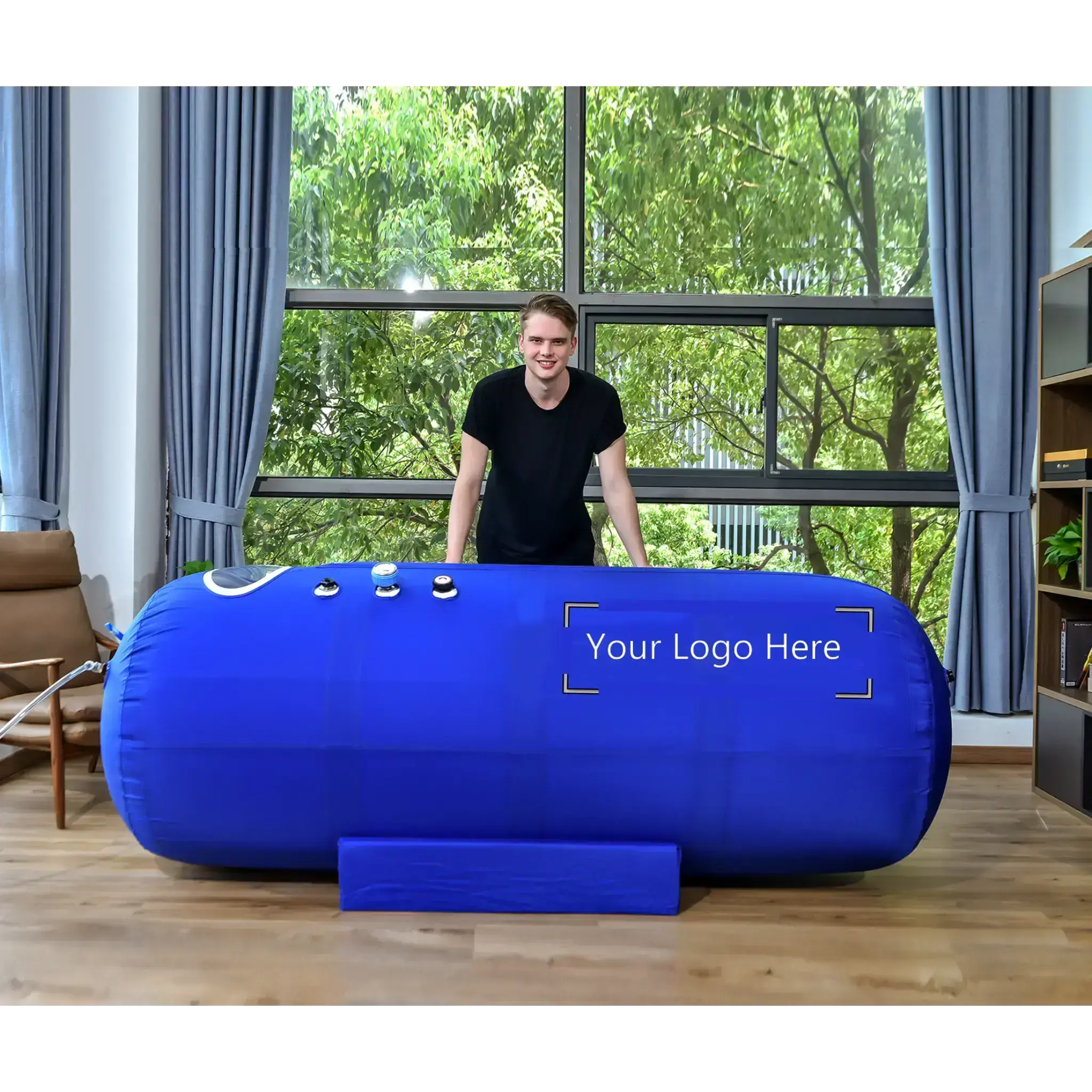 Macy-Pan ST901 Soft Lying Hyperbaric Oxygen Therapy Chamber in a home setting with a person standing beside it.