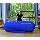 Macy-Pan ST901 Soft Lying Hyperbaric Oxygen Therapy Chamber in a home setting with a person standing beside it.