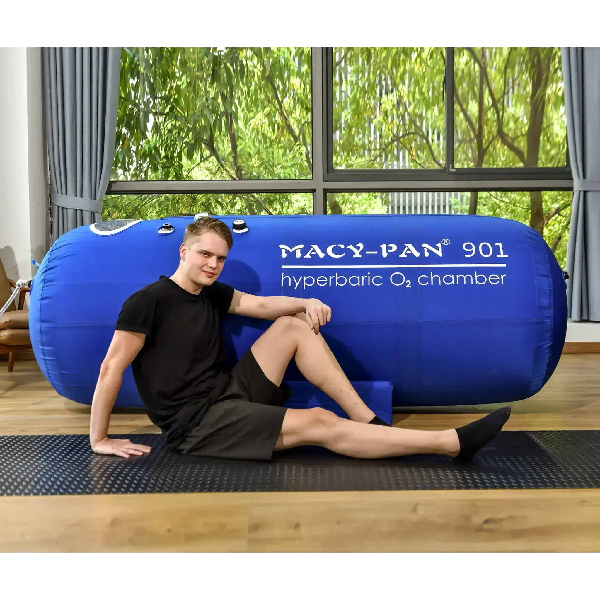 Man resting beside Macy-Pan ST901 hyperbaric oxygen therapy chamber for optimal healing and recovery.