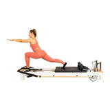 Align Pilates C8-S Pro white reformer in use, side view on standard legs