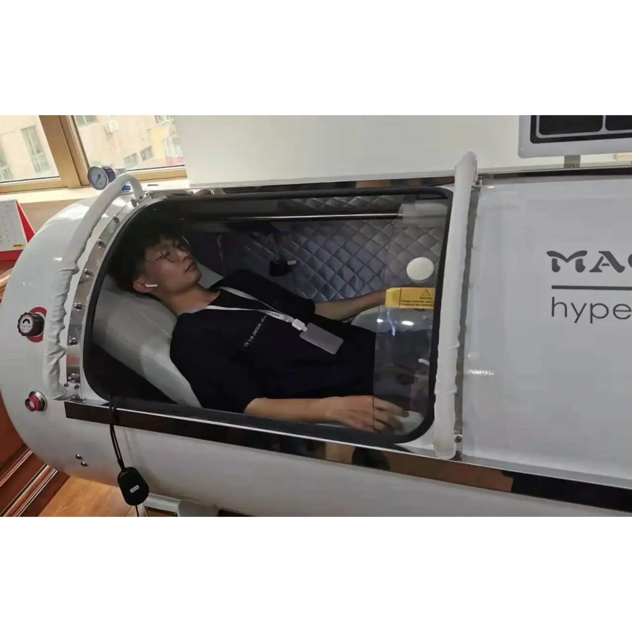 Person relaxing inside Macy-Pan HP1501 hyperbaric oxygen therapy chamber for enhanced recovery.