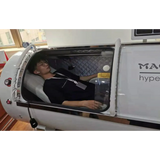 Person relaxing inside Macy-Pan HP1501 hyperbaric oxygen therapy chamber for enhanced recovery.