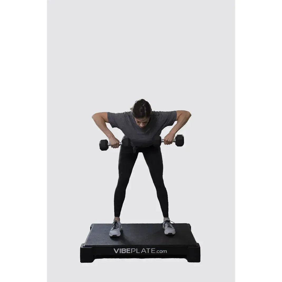 Female Model using dumbell on Vibeplate 2440 whole body vibration machines