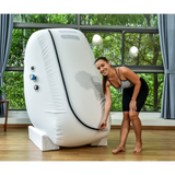 Woman adjusting the zipper of a Macy-Pan L1 Seated Hyperbaric Oxygen Therapy Chamber in a bright room.