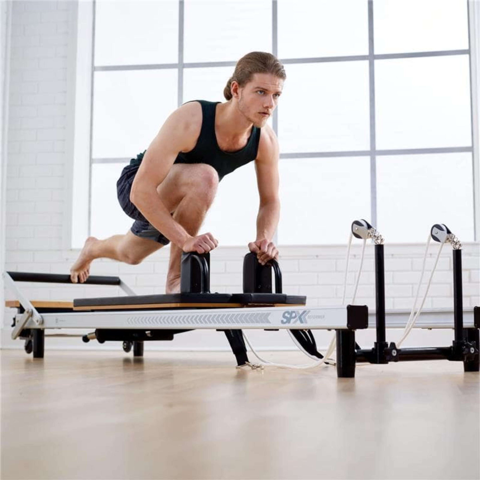 Male doing advanced balance workout on Merrithew SPX Max Reformer
