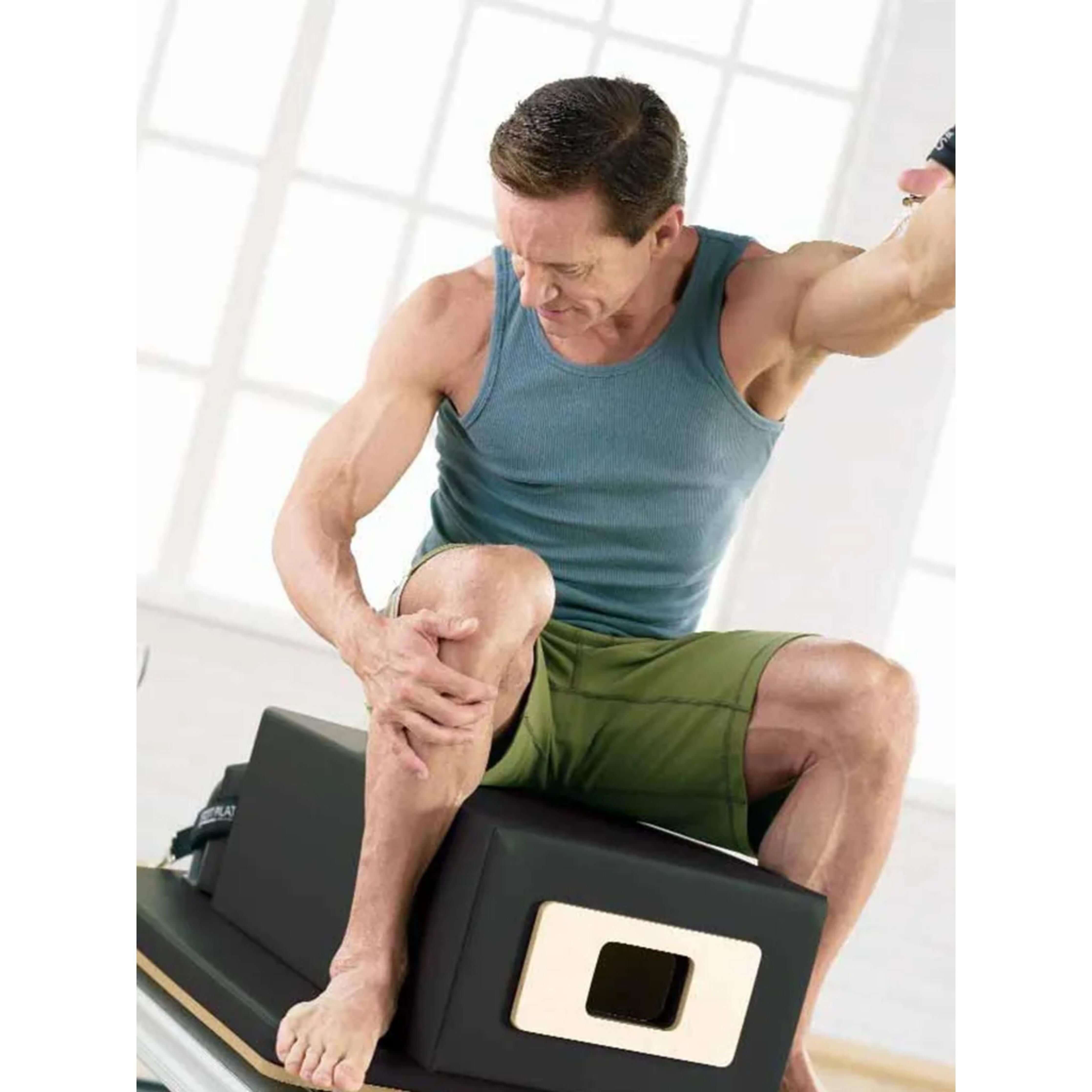 Focused male exercising on Merrithew SPX Max Plus Reformer bundle