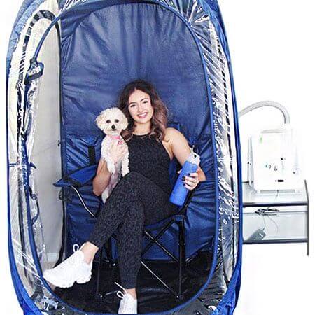 Woman and dog sitting in a home salt therapy setup with a HaloPod - RecovAthlete