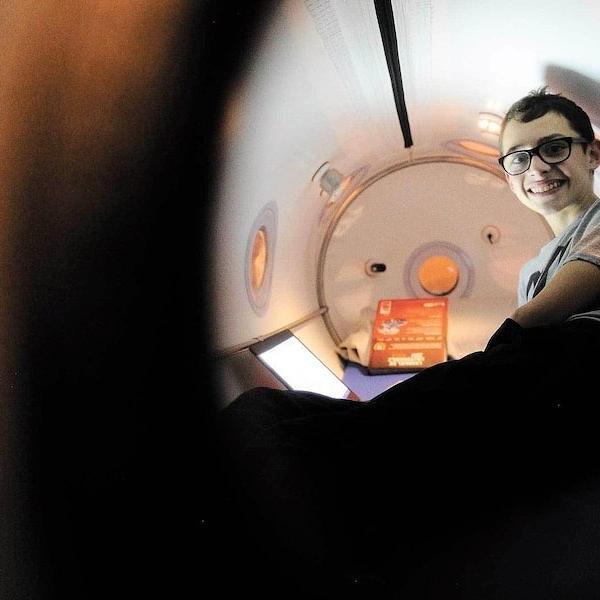 child happily sitting inside of Oxynova 8 chamber