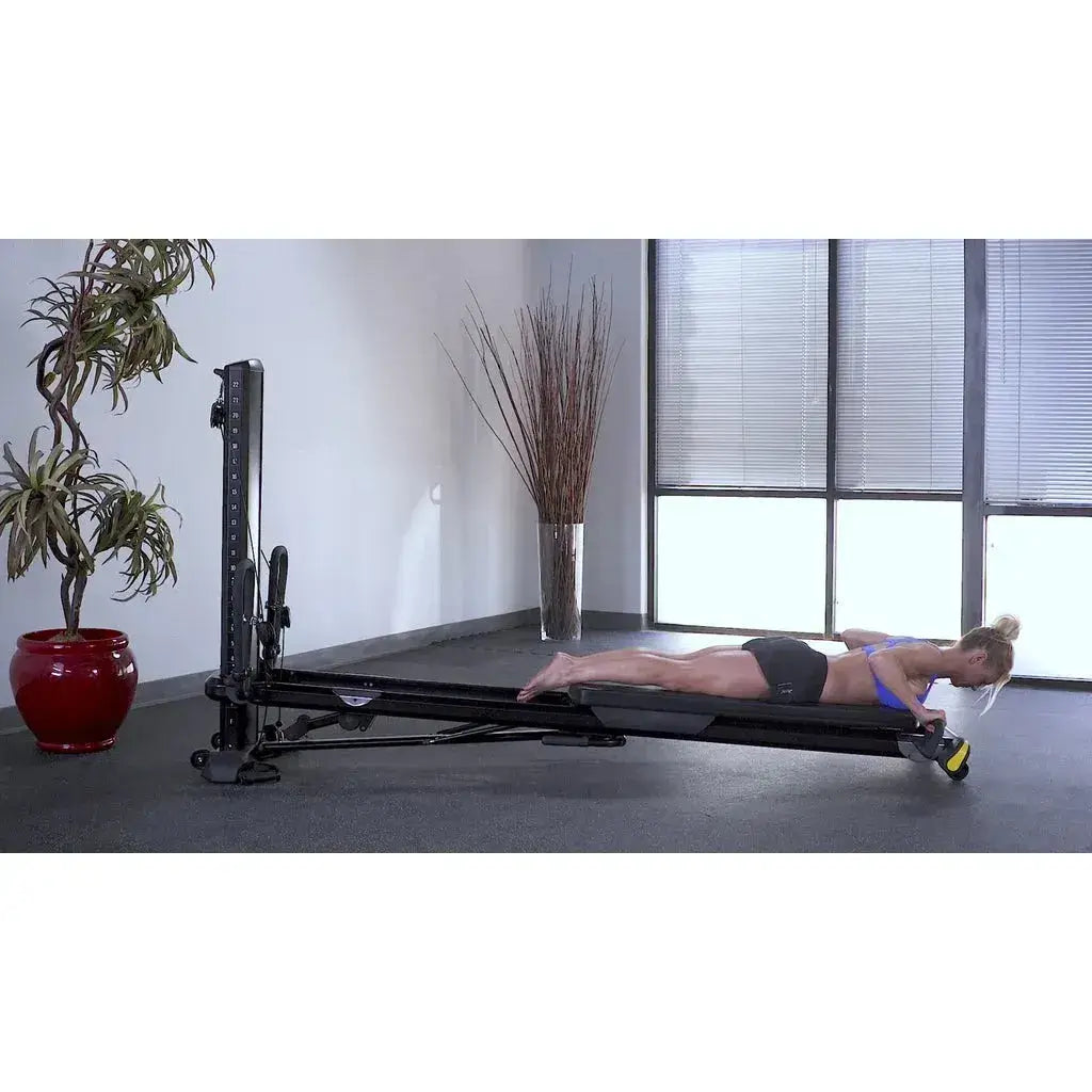 female model doing extensions on Total Gym ELEVATE Encompass™ Pilates Package