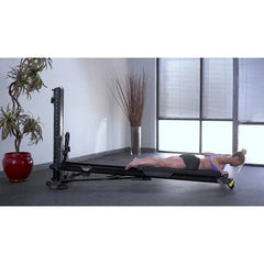 female model doing extensions on Total Gym ELEVATE Encompass™ Pilates Package