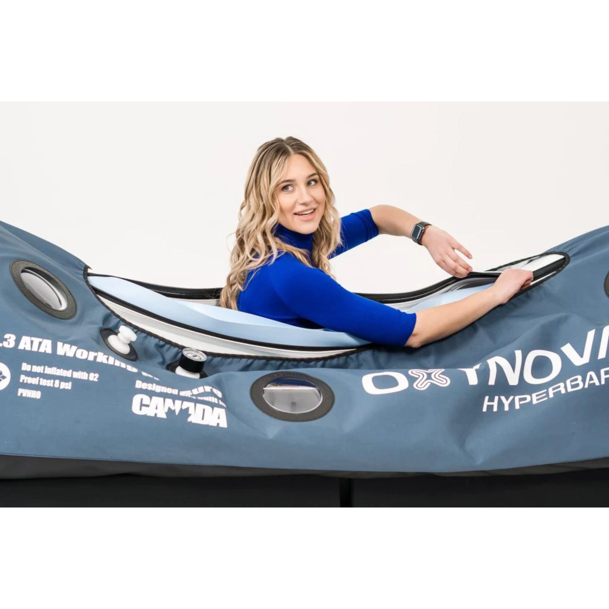 female model opening the oxynova 7 soft‑shell hbot