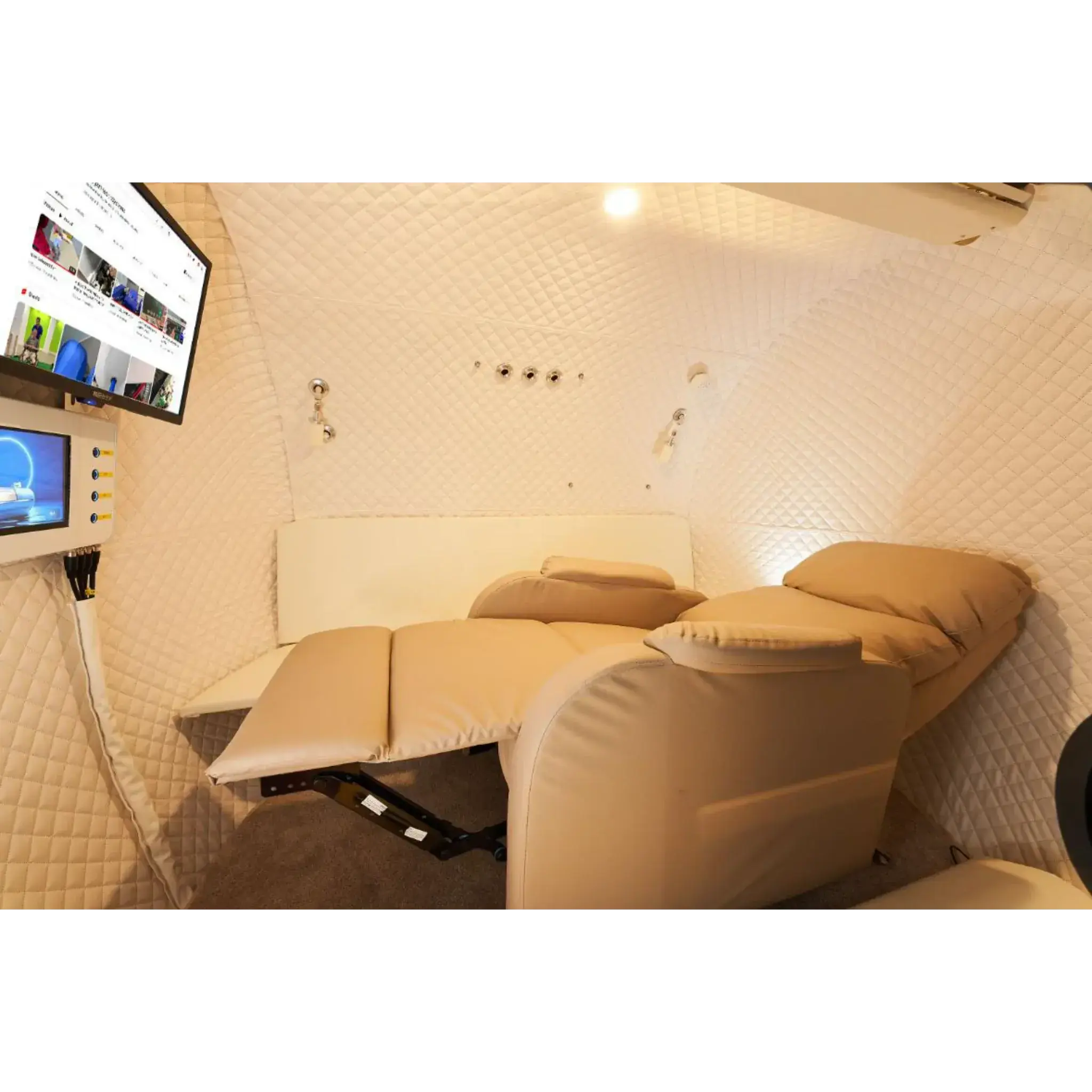 Interior view of the Macy-Pan HE5000 Hyperbaric Oxygen Therapy Chamber with reclining seats and touchscreen.