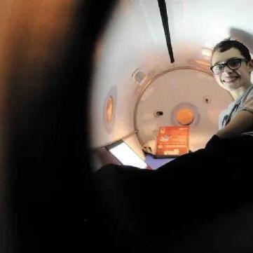 Toddler reading a book inside oxynova 7 mild hyperbaric chamber