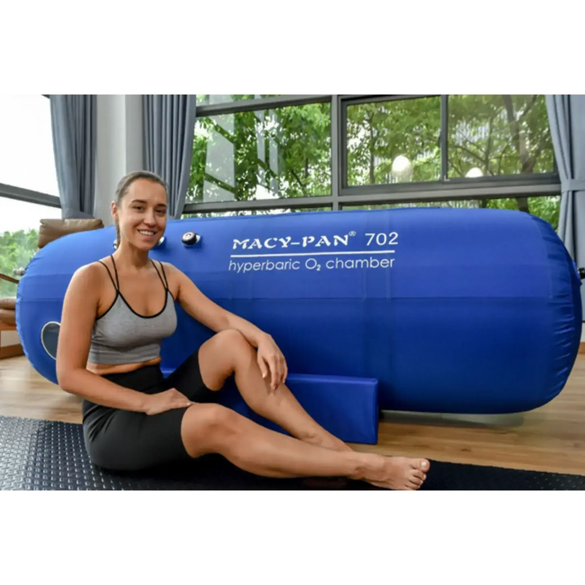 Macy-Pan ST702 Hyperbaric Oxygen Therapy Chamber with a woman sitting beside it, showcasing wellness and recovery benefits.