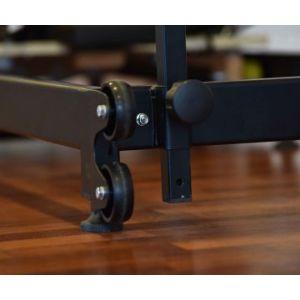 Close-up of private Pilates premium foldable metal reformer wheels and frame detail on wooden floor