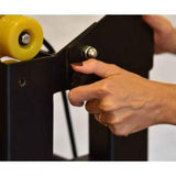 Close-up of a hand adjusting the mechanism on a premium foldable Pilates reformer.