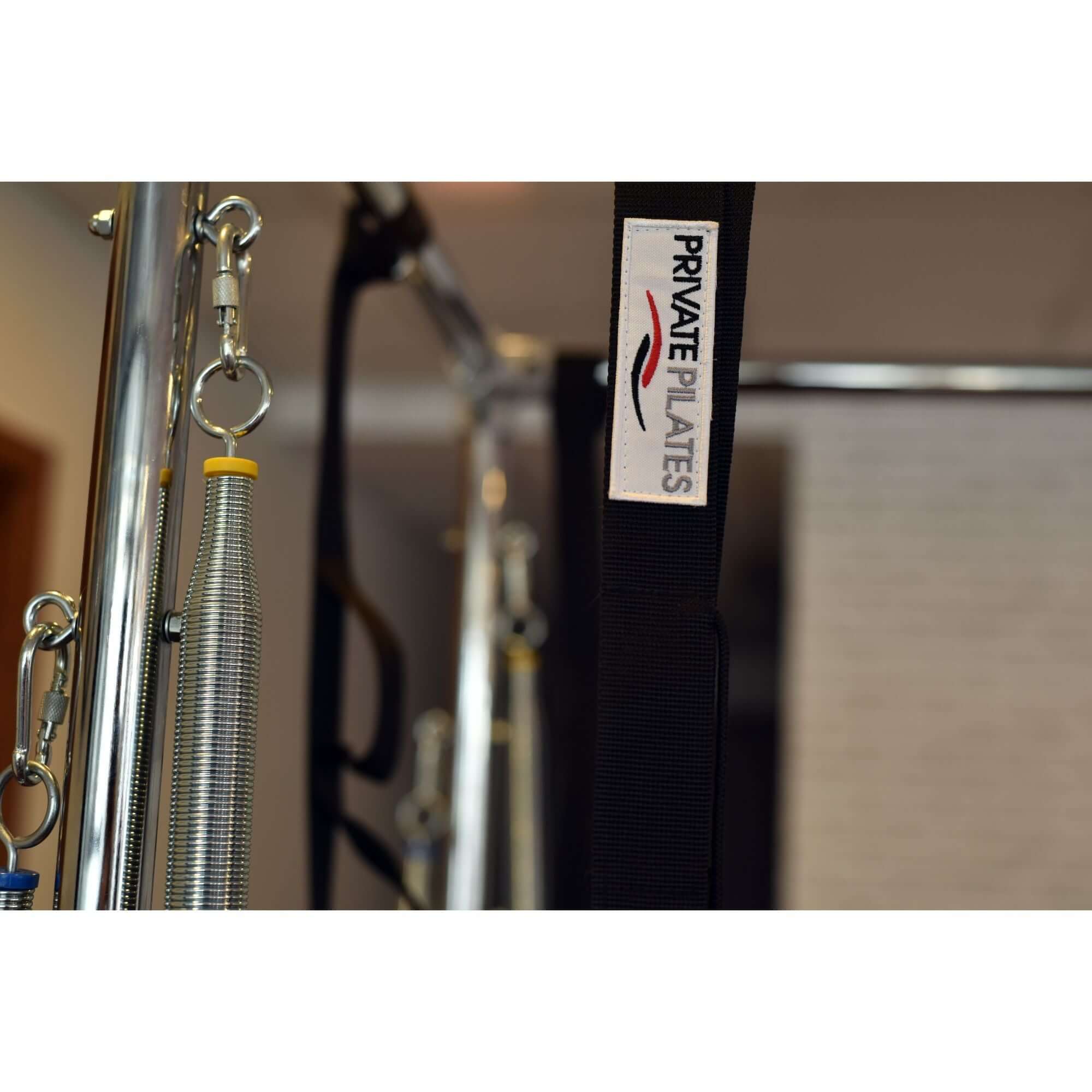 Close-up of Private Pilates strap and metal springs on a premium Pilates reformer.