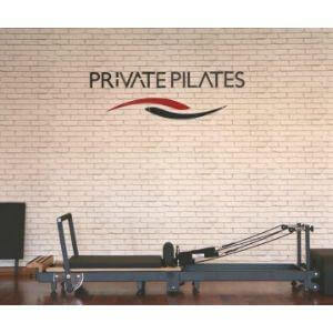 Private Pilates premium foldable metal reformer against a brick wall in a studio setting.