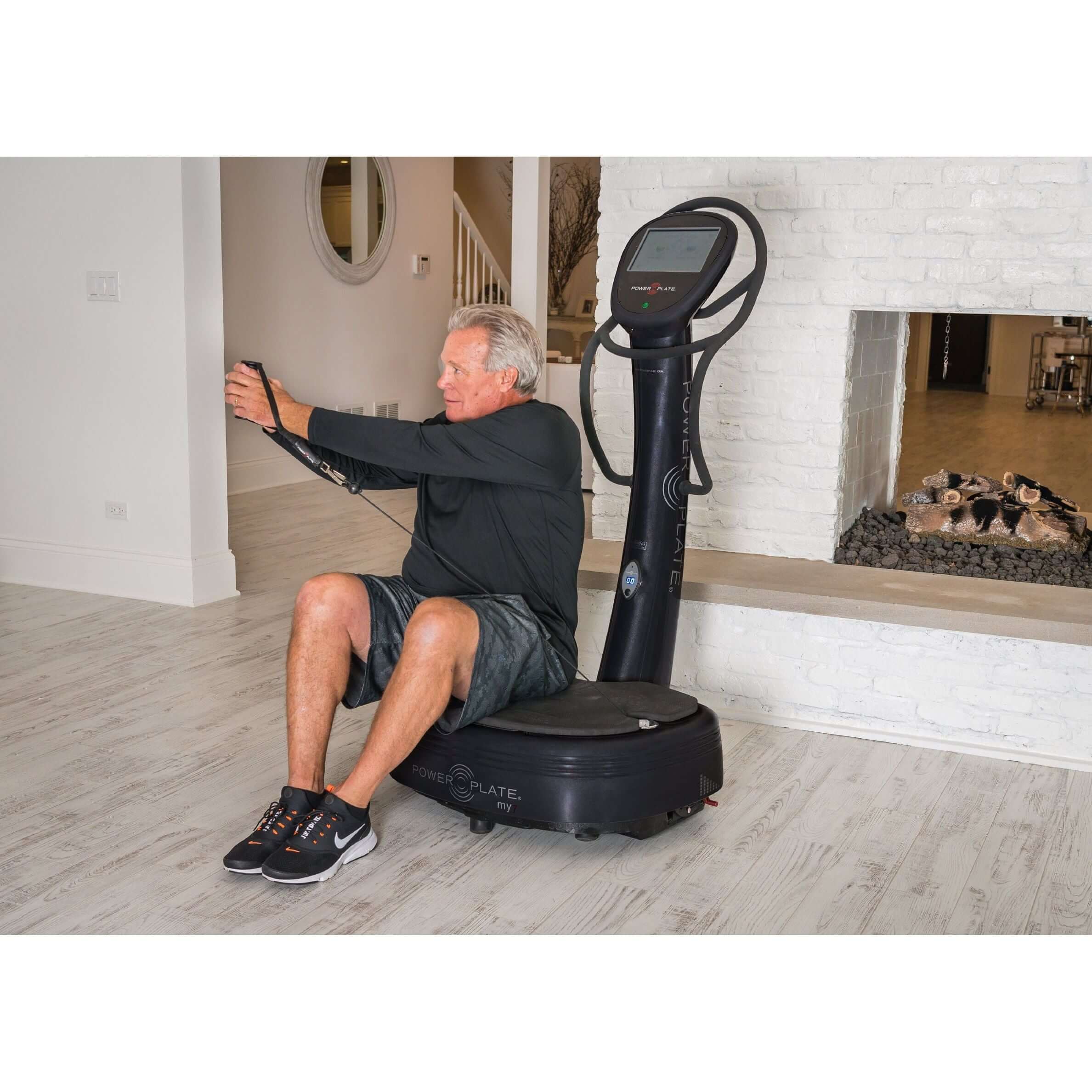 Power Plate my7 whole body vibration machine front view old man sitting and doing exercise