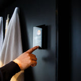 Hand adjusting a Harvia Fenix FX001XW sauna control panel