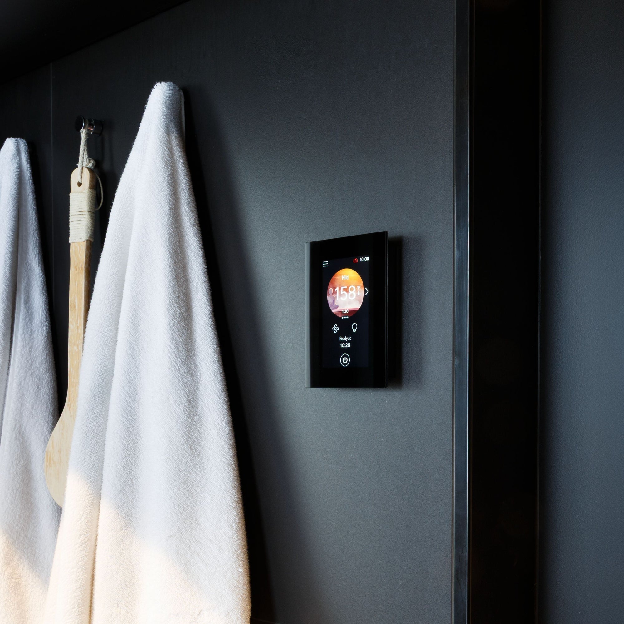Harvia Fenix sauna control panel on a changing room wall