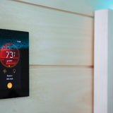 Harvia Fenix sauna control touchscreen mounted on a light wood sauna wall