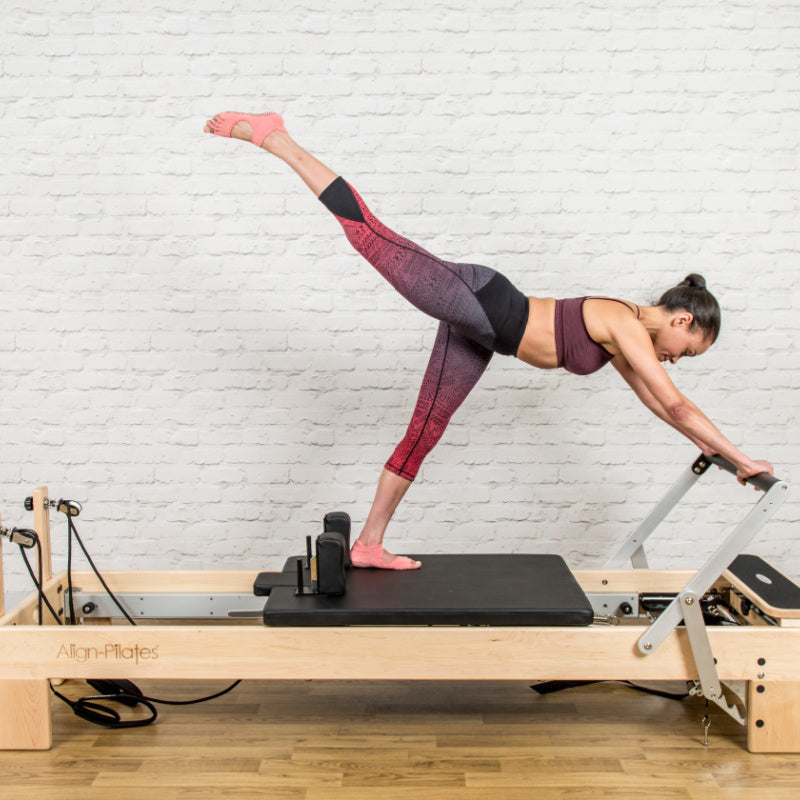 Align Pilates M8-Pro maple reformer with Half Cadillac, footbar and carriage from the side in a studio