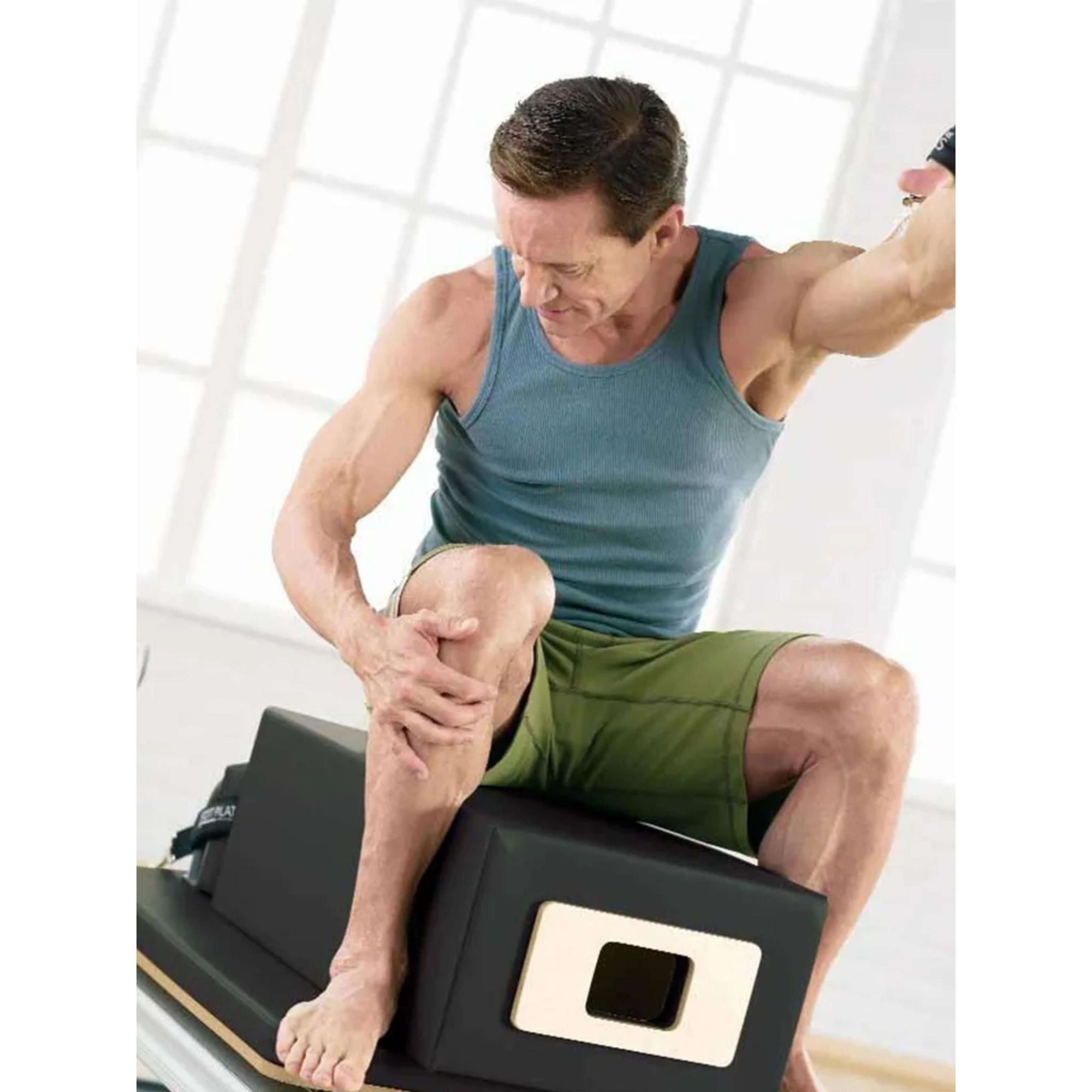 Focused male exercising on Merrithew SPX Max Plus Reformer bundle
