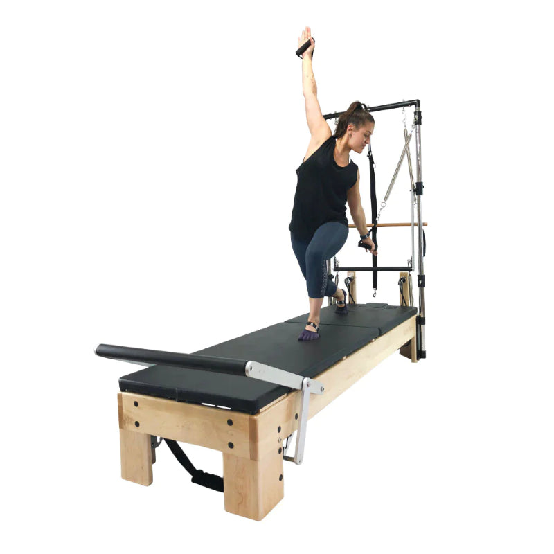 Align Pilates M8-Pro maple reformer with Half Cadillac, instructor using the tower arm springs, diagonal view