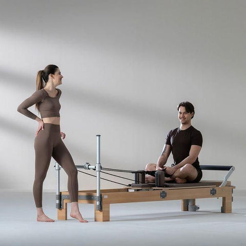 couple exercising on pilates reformer basi