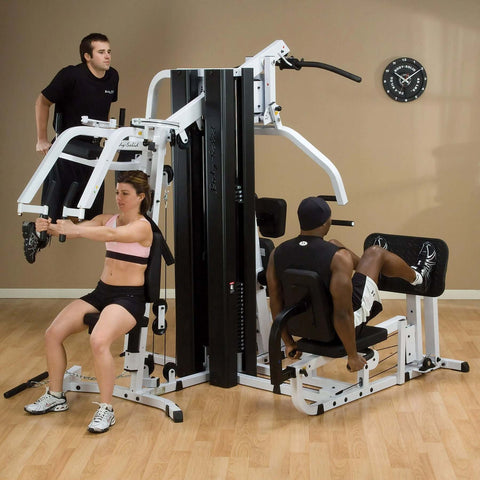 three people working out on body solid exm3000lps home gym