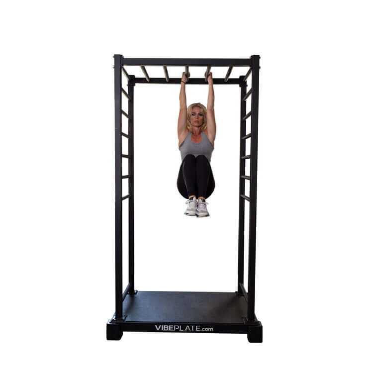 Woman performing a hanging stretch on the VibePlate VibeStretch vibration platform for flexibility training